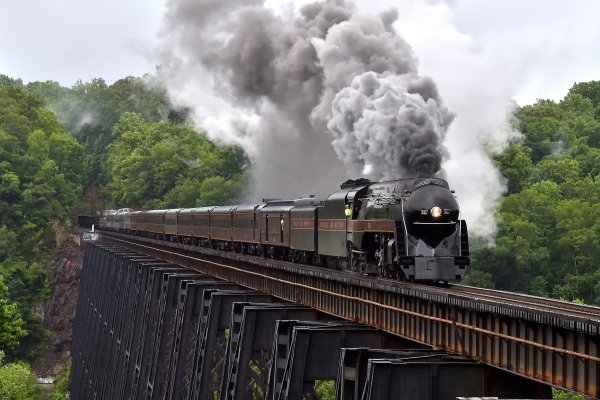 Norfolk and Western class J number 611 storms across the James River bridge leaving Lynchburg, Virginia. Road Foreman of Engines Don Woods is occupying the engineer's seat as the 23-car train makes a ferry run from Roanoke to Manassas where it will operate public excursions this weekend.